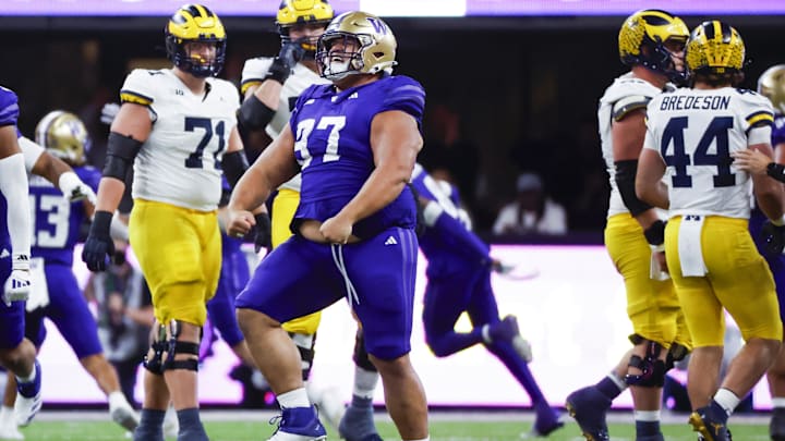 Huskies defensive lineman Logan Sagapolu (97) celebrates after recovering a fumble against Michigan.