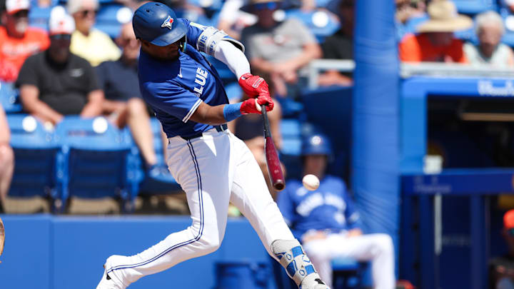 Mar 13, 2025: Toronto Blue Jays second baseman Orelvis Martinez (13) hits a base hit against the Baltimore Orioles in the second inning during spring training at TD Ballpark. 