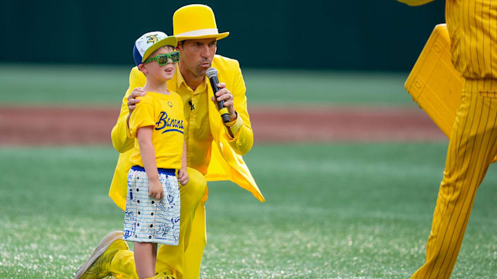 Jun 7, 2025; Charlotte, NC, USA;   Team owner and master of ceremonies Jesse Cole with a young fan ready to peel the opening banana during the exhibition game between the Savannah Bananas and the Pary Animals at Bank of America Stadium. Mandatory Credit: Jim Dedmon-Imagn Images