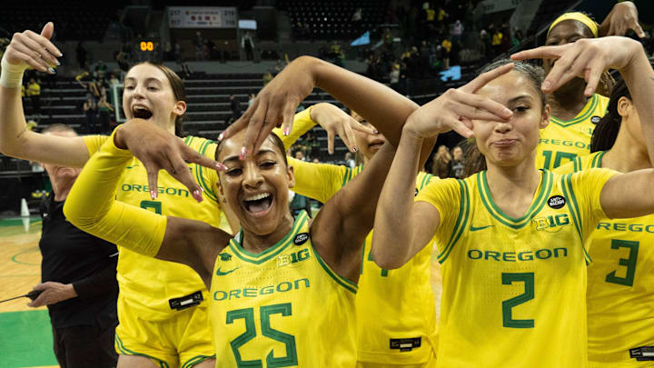 Oregon’s Elisa Mevius, left, Deja Kelly and Katie Fiso celebrate with teammates after defeating Washington at Matthew Knight Arena on Wednesday, Feb. 12, 2025.