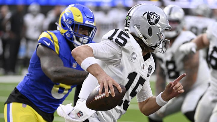 Oct 20, 2024; Inglewood, California, USA; Las Vegas Raiders quarterback Gardner Minshew (15) scrambles away from  Los Angeles Rams linebacker Jared Verse (8) in the second half at SoFi Stadium. Mandatory Credit: Alex Gallardo-Imagn Images