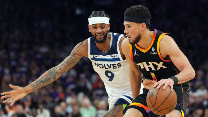 Apr 28, 2024; Phoenix, Arizona, USA; Minnesota Timberwolves guard Nickeil Alexander-Walker (9) guards Phoenix Suns guard Devin Booker (1) during the second half of game four of the first round for the 2024 NBA playoffs at Footprint Center. Mandatory Credit: Joe Camporeale-USA TODAY Sports