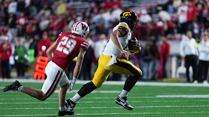 Oct 11, 2025; Madison, Wisconsin, USA; Iowa Hawkeyes quarterback Mark Gronowski (11) runs the ball while being chased by Wisconsin Badgers safety Matthew Jung (29) during the second half at Camp Randall Stadium. Mandatory Credit: Ross Harried-Imagn Images