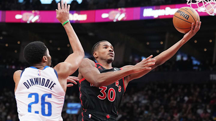 Dec 7, 2024; Toronto, Ontario, CAN; Toronto Raptors guard Ochai Agbaji (30) drives to the basket against Dallas Mavericks guard Spencer Dinwiddie (26) during the fourth quarter at Scotiabank Arena. Mandatory Credit: Nick Turchiaro-Imagn Images