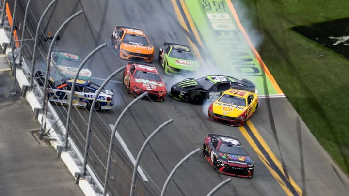 Feb 15, 2026; Daytona Beach, Florida, USA; NASCAR Cup Series driver Tyler Reddick (45) leads the field to the checkered flag as Chase Elliott (9), Joey Logano (22), and Riley Herbst (35) crash during the 68th running of the Daytona 500 at Daytona International Speedway.