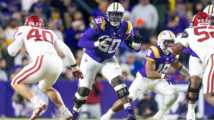 Nov 30, 2024; Baton Rouge, Louisiana, USA;  LSU Tigers offensive lineman Emery Jones Jr. (50) defends the line against Oklahoma Sooners defensive lineman Ethan Downs (40) during the first quarter at Tiger Stadium. Mandatory Credit: Stephen Lew-Imagn Images