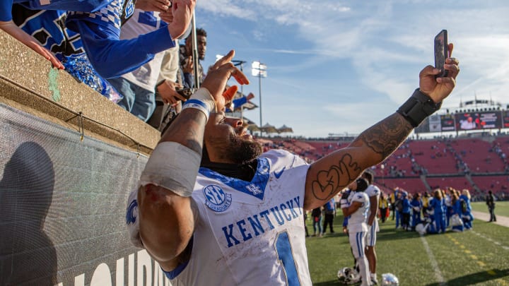 Kentucky's Ray Davis (1) took photos with fans after Kentucky defeated Louisville 38-31 on Saturday afternoon at L&N Stadium in Louisville, Ky. Nov. 25, 2023.