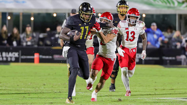 Nov 29, 2024; Orlando, Florida, USA; UCF Knights quarterback Jacurri Brown (11) is tackled by Utah Utes cornerback Smith Snowden (2) during the second half at FBC Mortgage Stadium. Mandatory Credit: Mike Watters-Imagn Images