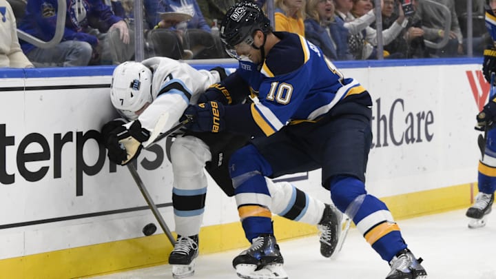 Nov 7, 2024; St. Louis, Missouri, USA; St. Louis Blues center Brayden Schenn (10) checks Utah Hockey Club defenseman Michael Kesselring (7) during the second  period at Enterprise Center. Mandatory Credit: Jeff Le-Imagn Images