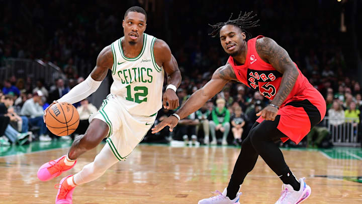 Oct 13, 2024; Boston, Massachusetts, USA;  Boston Celtics guard Lonnie Walker IV (12) controls the ball while Toronto Raptors guard Davion Mitchell (45) defends during the first half at TD Garden. Mandatory Credit: Bob DeChiara-Imagn Images