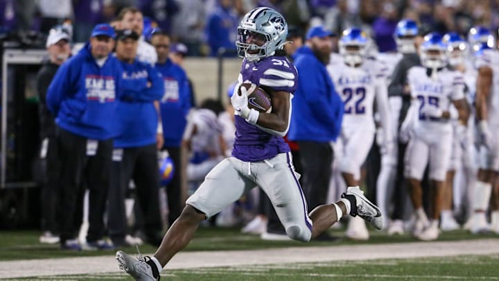 Oct 26, 2024; Manhattan, Kansas, USA; Kansas State Wildcats running back DJ Giddens (31) tries to run from Kansas Jayhawks cornerback Mello Dotson (3) during the fourth quarter at Bill Snyder Family Football Stadium. Mandatory Credit: Scott Sewell-Imagn Images