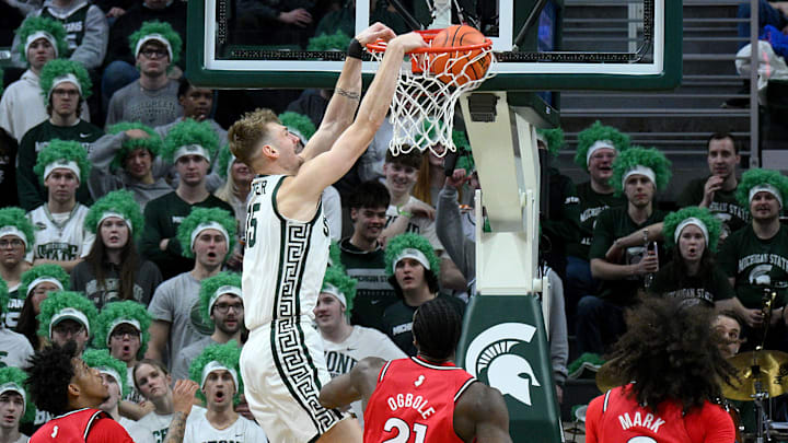 Mar 5, 2026; East Lansing, Michigan, USA;  Michigan State Spartans center Carson Cooper (15) dunks the ball past the Rutgers Scarlet Knights defense during the first half at Jack Breslin Student Events Center. Mandatory Credit: Dale Young-Imagn Images