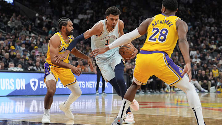 Nov 27, 2024; San Antonio, Texas, USA;  San Antonio Spurs center Victor Wembanyama (1) dribbles between Los Angeles Lakers guard Gabe Vincent (7) and forward Rui Hachimura (28) in the first half at Frost Bank Center. Mandatory Credit: Daniel Dunn-Imagn Images