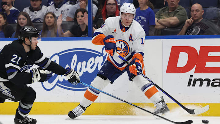 Mar 29, 2025; Tampa, Florida, USA; New York Islanders center Bo Horvat (14) passes the puck as Tampa Bay Lightning center Brayden Point (21) defends during the first period at Amalie Arena. Mandatory Credit: Kim Klement Neitzel-Imagn Images
