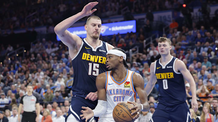 Mar 10, 2025; Oklahoma City, Oklahoma, USA; Denver Nuggets center Nikola Jokic (15) defends a drive by Oklahoma City Thunder guard Shai Gilgeous-Alexander (2) during the second half at Paycom Center. Mandatory Credit: Alonzo Adams-Imagn Images