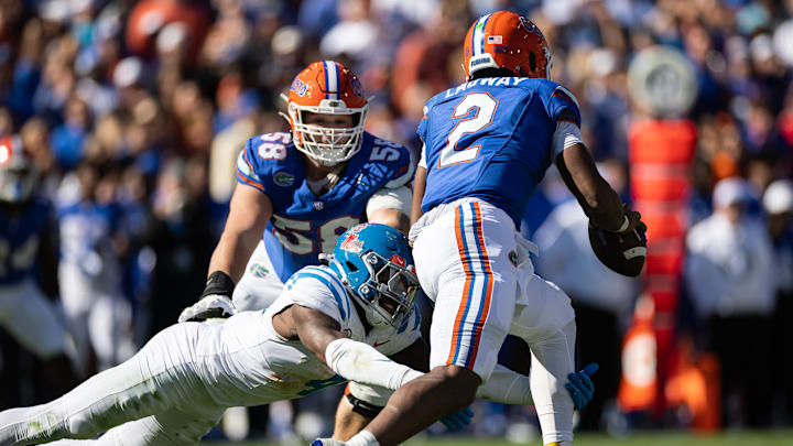 Nov 23, 2024; Gainesville, Florida, USA; Mississippi Rebels linebacker Suntarine Perkins (4) attempts to tackle Florida Gators quarterback DJ Lagway (2) during the first half at Ben Hill Griffin Stadium. Mandatory Credit: Matt Pendleton-Imagn Images