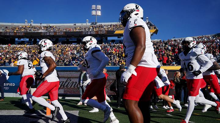 The Cincinnati Bearcats take the field prior to an NCAA college football game against the West Virginia Mountaineers, Saturday, Nov. 18, 2023, at Milan Puskar Stadium in Morgantown, W. Va. The Cincinnati Bearcats take the field prior to an NCAA college football game against the West Virginia Mountaineers, Saturday, Nov. 18, 2023, at Milan Puskar Stadium in Morgantown, W. Va.