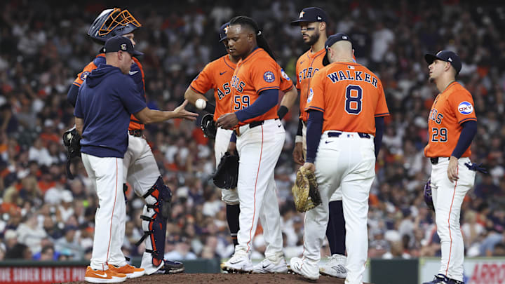 Aug 15, 2025; Houston, Texas, USA; Houston Astros starting pitcher Framber Valdez (59) tosses the ball to manager Joe Espada (19) during a pitching change in the seventh inning against the Baltimore Orioles at Daikin Park. 