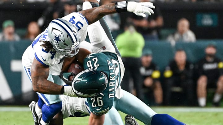 Philadelphia Eagles RB Saquon Barkley is tackled by Dallas Cowboys DE Sam Williams and CB Kaiir Elam.