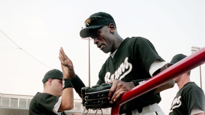 Former NBA great Michael Jordan, center, gets a high-fives from a teammate after making a play in the outfield for the Birmingham Barons against the Nashville Xpress in the first game of a double header at Greer Stadium on Aug. 2, 1994.