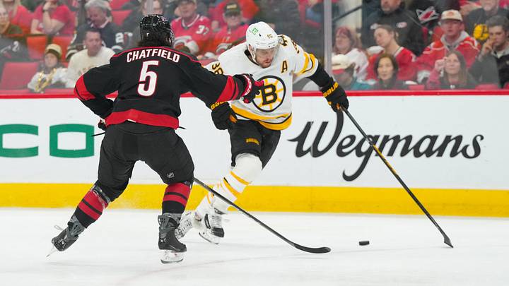 Apr 7, 2026; Raleigh, North Carolina, USA; Boston Bruins right wing David Pastrnak (88) skates with the puck against Carolina Hurricanes defenseman Jalen Chatfield (5) during the second period at Lenovo Center. Mandatory Credit: James Guillory-Imagn Images