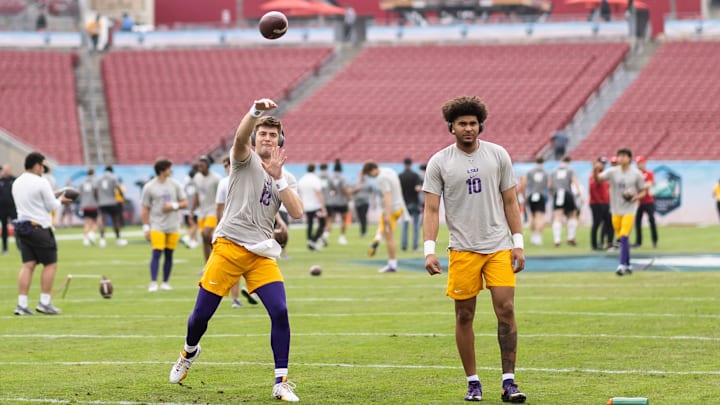 Jan 1, 2024; Tampa, FL, USA; LSU Tigers quarterbacks Garrett Nussmeier (13) and Rickie Collins (10) participate in drills before the game against the Wisconsin Badgers at Raymond James Stadium. Mandatory Credit: Matt Pendleton-Imagn Images
