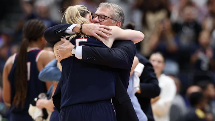 Apr 6, 2025; Tampa, FL, USA; Connecticut Huskies head coach Geno Auriemma hugs guard Paige Bueckers (5) during the second half against the South Carolina Gamecocks of the national championship of the women's 2025 NCAA tournament at Amalie Arena. Mandatory Credit: Nathan Ray Seebeck-Imagn Images Apr 6, 2025; Tampa, FL, USA; Connecticut Huskies head coach Geno Auriemma hugs guard Paige Bueckers (5) during the second half against the South Carolina Gamecocks of the national championship of the women's 2025 NCAA tournament at Amalie Arena. Mandatory Credit: Nathan Ray Seebeck-Imagn Images