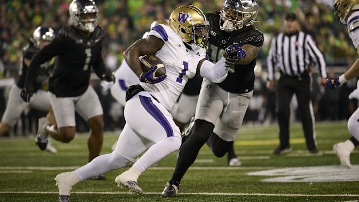 The UW's Jonah Coleman tries to skirt the corner against Oregon and Ducks defensive end Matayo Uiagalelei (10). The UW's Jonah Coleman tries to skirt the corner against Oregon and Ducks defensive end Matayo Uiagalelei (10).