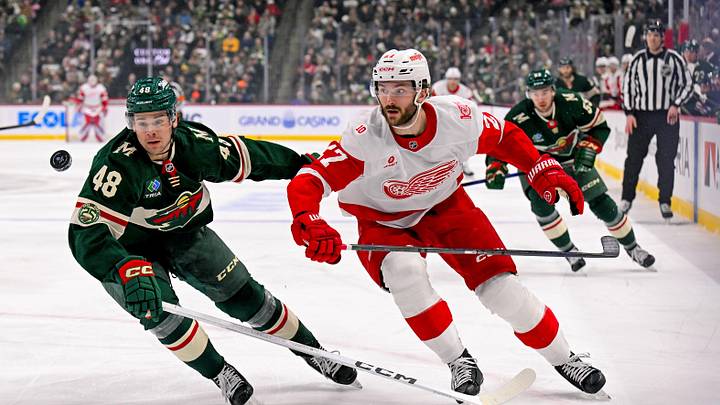 Jan 22, 2026; Saint Paul, Minnesota, USA;  Minnesota Wild defensemen Daemon Hunt (48) and Detroit Red Wings forward Michael Rasmussen (27) race after a loose puck during the first period at Grand Casino Arena. Mandatory Credit: Nick Wosika-Imagn Images
