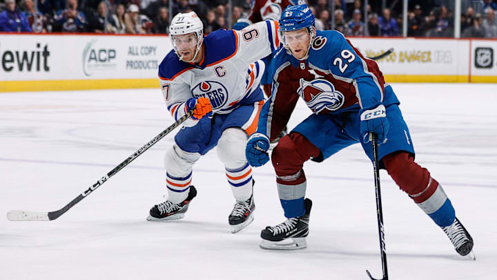 Feb 19, 2023; Denver, Colorado, USA; Colorado Avalanche center Nathan MacKinnon (29) controls the puck ahead of Edmonton Oilers center Connor McDavid (97) in overtime at Ball Arena. Mandatory Credit: Isaiah J. Downing-Imagn Images