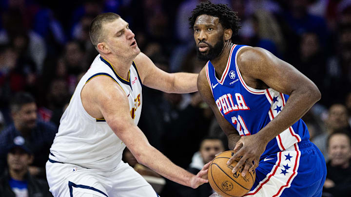 Philadelphia 76ers center Joel Embiid (21) controls the ball against Denver Nuggets center Nikola Jokic (15) during the first quarter at Wells Fargo Center. Mandatory Credit: Bill Streicher-Imagn Images