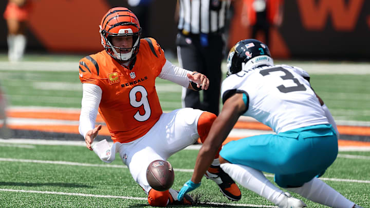 Sep 14, 2025; Cincinnati, Ohio, USA;  Cincinnati Bengals quarterback Joe Burrow (9) goes for the loose ball with Jacksonville Jaguars cornerback Tyson Campbell (3) during the first quarter at Paycor Stadium. Mandatory Credit: Joseph Maiorana-Imagn Images