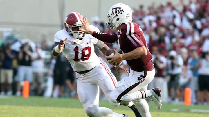 Texas A&M Aggies quarterback Johnny Manziel stiff arms Alabama Crimson Tide linebacker Reggie Ragland. Texas A&M Aggies quarterback Johnny Manziel stiff arms Alabama Crimson Tide linebacker Reggie Ragland.