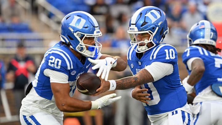 Nov 15, 2025; Durham, North Carolina, USA; Duke Blue Devils quarter back Darian Mensah (10) hands the ball to Duke Blue Devils running back Nate Sheppard (20) against the Virginia Cavaliers during the first quarter at Wallace Wade Stadium. Mandatory Credit: Zachary Taft-Imagn Images