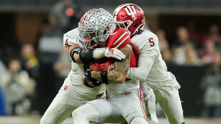 Indiana Hoosiers linebacker Aiden Fisher (4) and Indiana Hoosiers defensive back D'Angelo Ponds (5) wrap up Ohio State Buckeyes wide receiver Brandon Inniss (1) on Saturday, Dec. 6, 2025, during the Big Ten football championship at Lucas Oil Stadium in Indianapolis. Indiana Hoosiers linebacker Aiden Fisher (4) and Indiana Hoosiers defensive back D'Angelo Ponds (5) wrap up Ohio State Buckeyes wide receiver Brandon Inniss (1) on Saturday, Dec. 6, 2025, during the Big Ten football championship at Lucas Oil Stadium in Indianapolis.