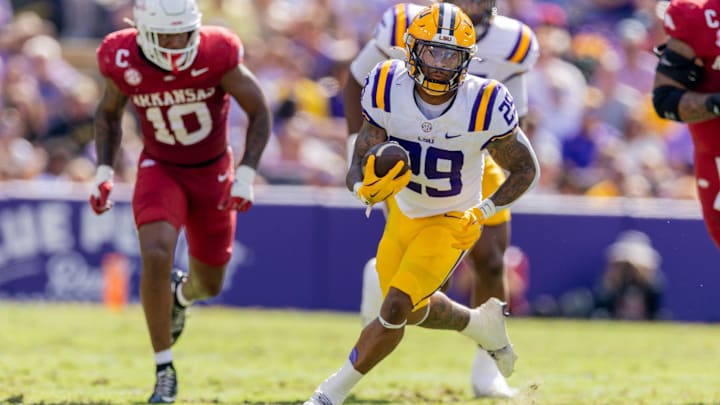 Nov 15, 2025; Baton Rouge, Louisiana, USA;  LSU Tigers running back Caden Durham (29) runs against Arkansas Razorbacks linebacker Xavian Sorey (10) during the first half at Tiger Stadium. Mandatory Credit: Stephen Lew-Imagn Images