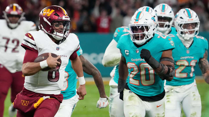 Washington Commanders quarterback Marcus Mariota (8) carries the ball against the Miami Dolphins in the fourth quarter during the 2025 NFL Madrid Game at Santiago Bernabeu Stadium.