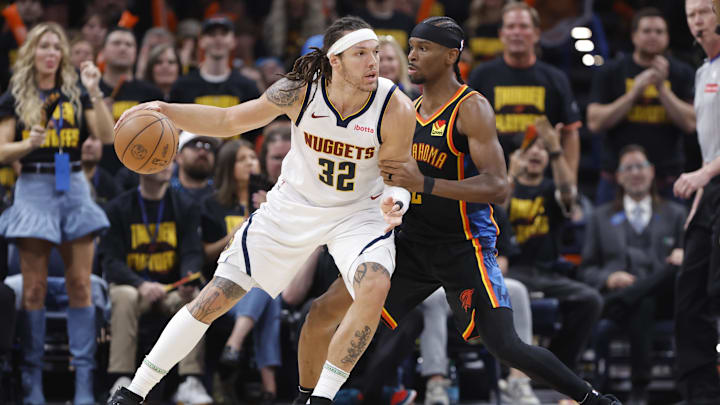 May 7, 2025; Oklahoma City, Oklahoma, USA; Denver Nuggets forward Aaron Gordon (32) drives against Oklahoma City Thunder guard Shai Gilgeous-Alexander (2) in the second half during game two of the second round for the 2025 NBA Playoffs at Paycom Center. Mandatory Credit: Alonzo Adams-Imagn Images