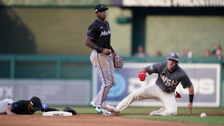Jun 14, 2024; Washington, District of Columbia, USA; Washington Nationals center fielder Jacob Young (30) slides into second base after an error by Miami Marlins shortstop Tim Anderson (7) in the third inning at Nationals Park. Mandatory Credit: Amber Searls-USA TODAY Sports