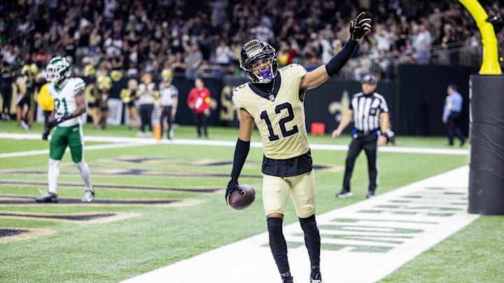 Dec 21, 2025; New Orleans, Louisiana, USA;  New Orleans Saints wide receiver Chris Olave (12) waves to fans after scoring a touchdown against New York Jets cornerback Brandon Stephens (21) during the second half  at Caesars Superdome. Mandatory Credit: Stephen Lew-Imagn Images