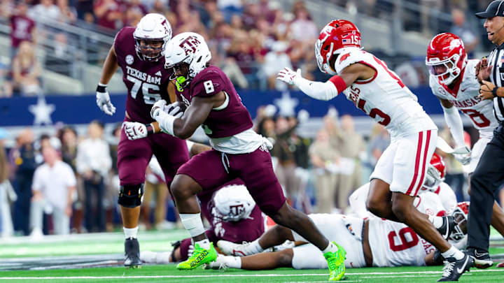 Sep 28, 2024; Arlington, Texas, USA;  Texas A&M Aggies running back Le'Veon Moss (8) runs with the ball as Arkansas Razorbacks defensive back Jaheim Singletary (15) defends during the second half at AT&T Stadium. Mandatory Credit: Kevin Jairaj-Imagn Images