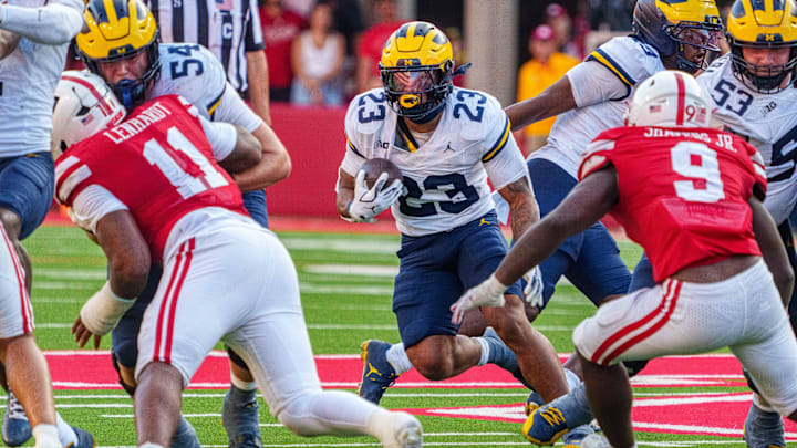Sep 20, 2025; Lincoln, Nebraska, USA; Michigan Wolverines running back Jordan Marshall (23) runs against Nebraska Cornhuskers linebacker Vincent Shavers Jr. (9) and defensive lineman Cameron Lenhardt (11) during the fourth quarter at Memorial Stadium. 