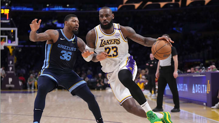 Dec 15, 2024; Los Angeles, California, USA; Los Angeles Lakers forward LeBron James (23) dribbles the ball against Memphis Grizzlies guard Marcus Smart (36) at Crypto.com Arena. Mandatory Credit: Kirby Lee-Imagn Images