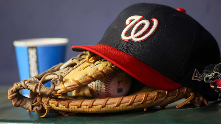 Dark blue Washington Nationals hat on top of a light brown mitt