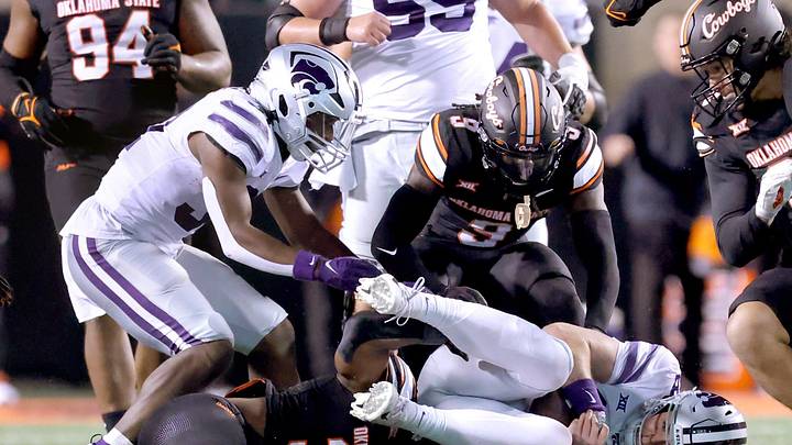 Kansas State's Will Howard (18) falls on a fumble as Oklahoma State's Collin Oliver (30) and Trey Rucker (9) defend in the second half of the college football game between the Oklahoma State University Cowboys and the Kansas State Wildcats at Boone Pickens Stadium in Stillwater. Okla., Friday, Oct. 6, 2023. OSU won 29-21.