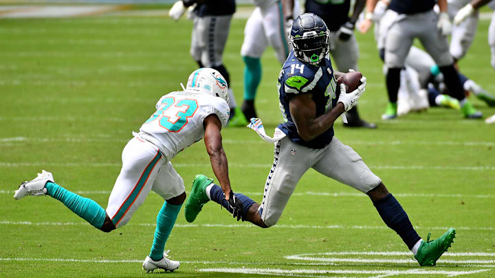 Oct 4, 2020; Miami Gardens, Florida, USA; Seattle Seahawks wide receiver DK Metcalf (14) runs with the ball around Miami Dolphins cornerback Noah Igbinoghene (23) during the first half at Hard Rock Stadium.