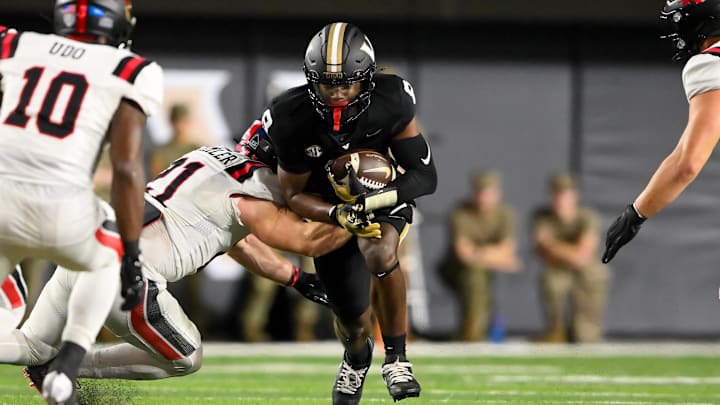Oct 19, 2024; Nashville, Tennessee, USA;  Vanderbilt Commodores quarterback Nate Johnson (8) gets tackled by Ball State Cardinals linebacker Joey Stemler (21) during the first half at FirstBank Stadium. 