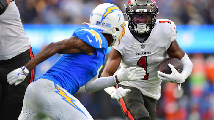 Dec 15, 2024; Inglewood, California, USA;  Tampa Bay Buccaneers running back Rachaad White (1) runs the ball against Los Angeles Chargers cornerback Kristian Fulton (7) during the first half at SoFi Stadium. Mandatory Credit: Gary A. Vasquez-Imagn Images