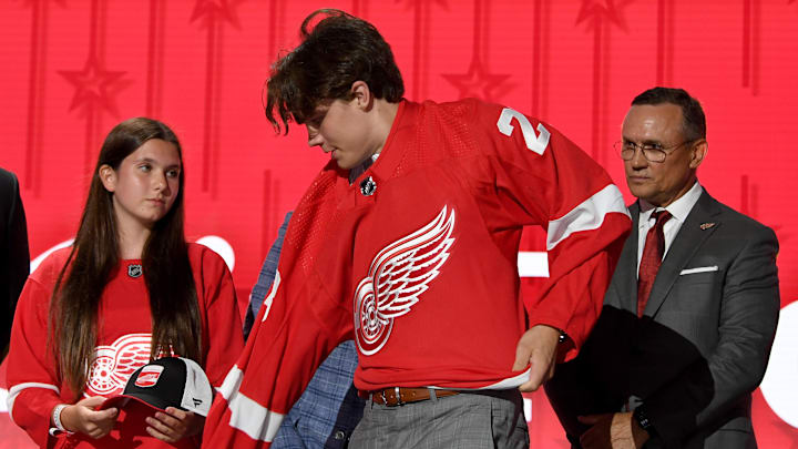 Jun 28, 2023; Nashville, Tennessee, USA; Detroit Red Wings draft pick Axel Sandin Pellikka puts on his sweater after being selected with the seventeenth pick in round one of the 2023 NHL Draft at Bridgestone Arena. Mandatory Credit: Christopher Hanewinckel-Imagn Images