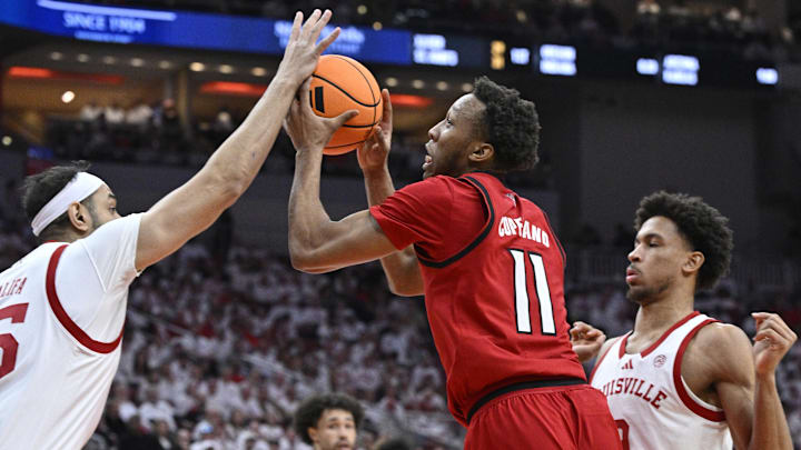 Feb 9, 2026; Louisville, Kentucky, USA;  NC State Wolfpack guard Quadir Copeland (11) shoots against Louisville Cardinals center Aly Khalifa (15) and forward Khani Rooths (9) during the first half at KFC Yum! Center. Mandatory Credit: Jamie Rhodes-Imagn Images